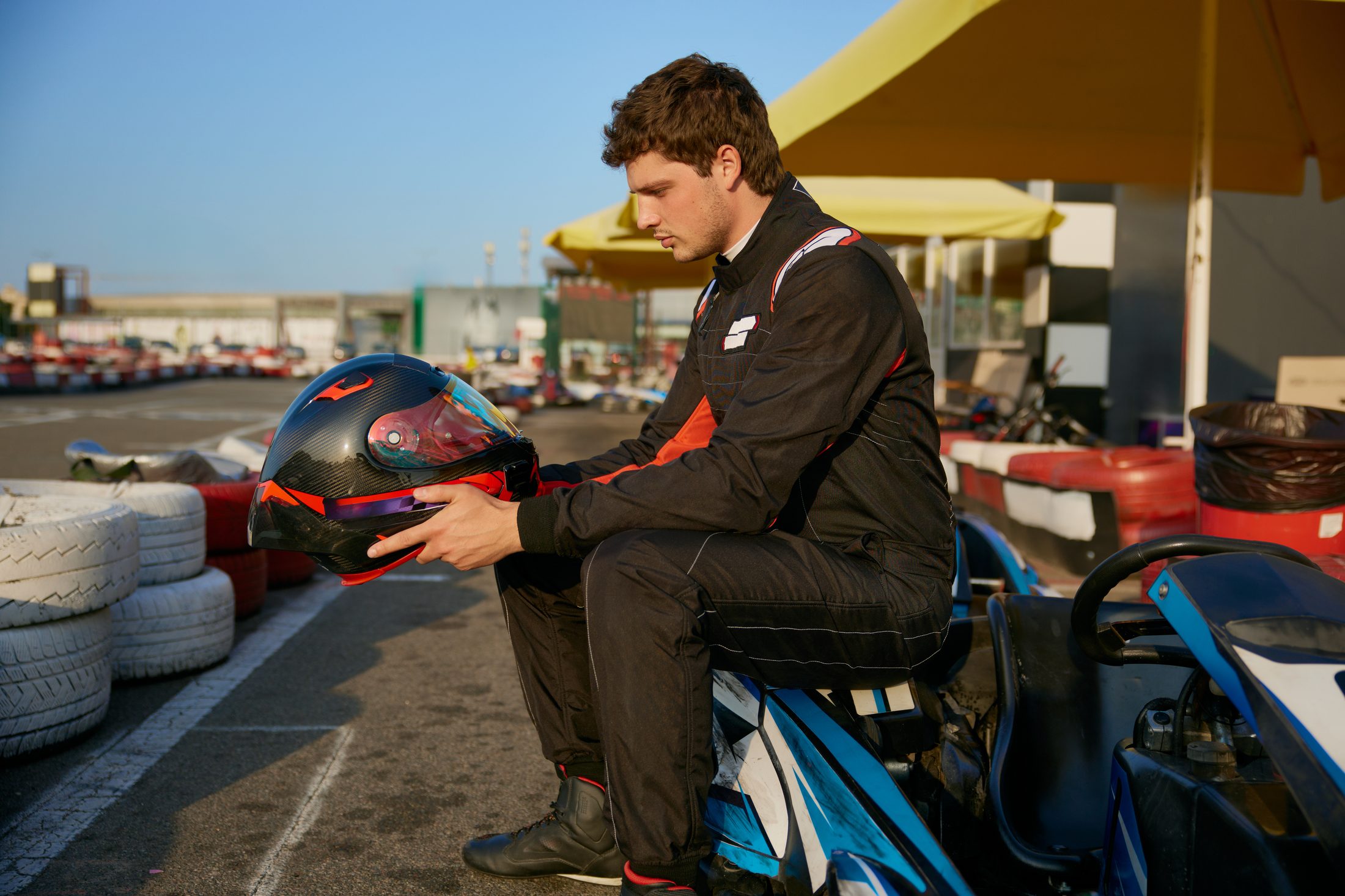 Racer holding a helmet at the karting track